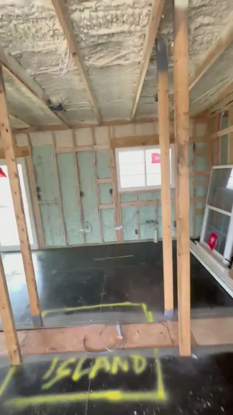 container-home-interior-spray-foam-insulation - JSC Contracting Inc Container home interior with spray foam insulation and kitchen island layout marked on the floor